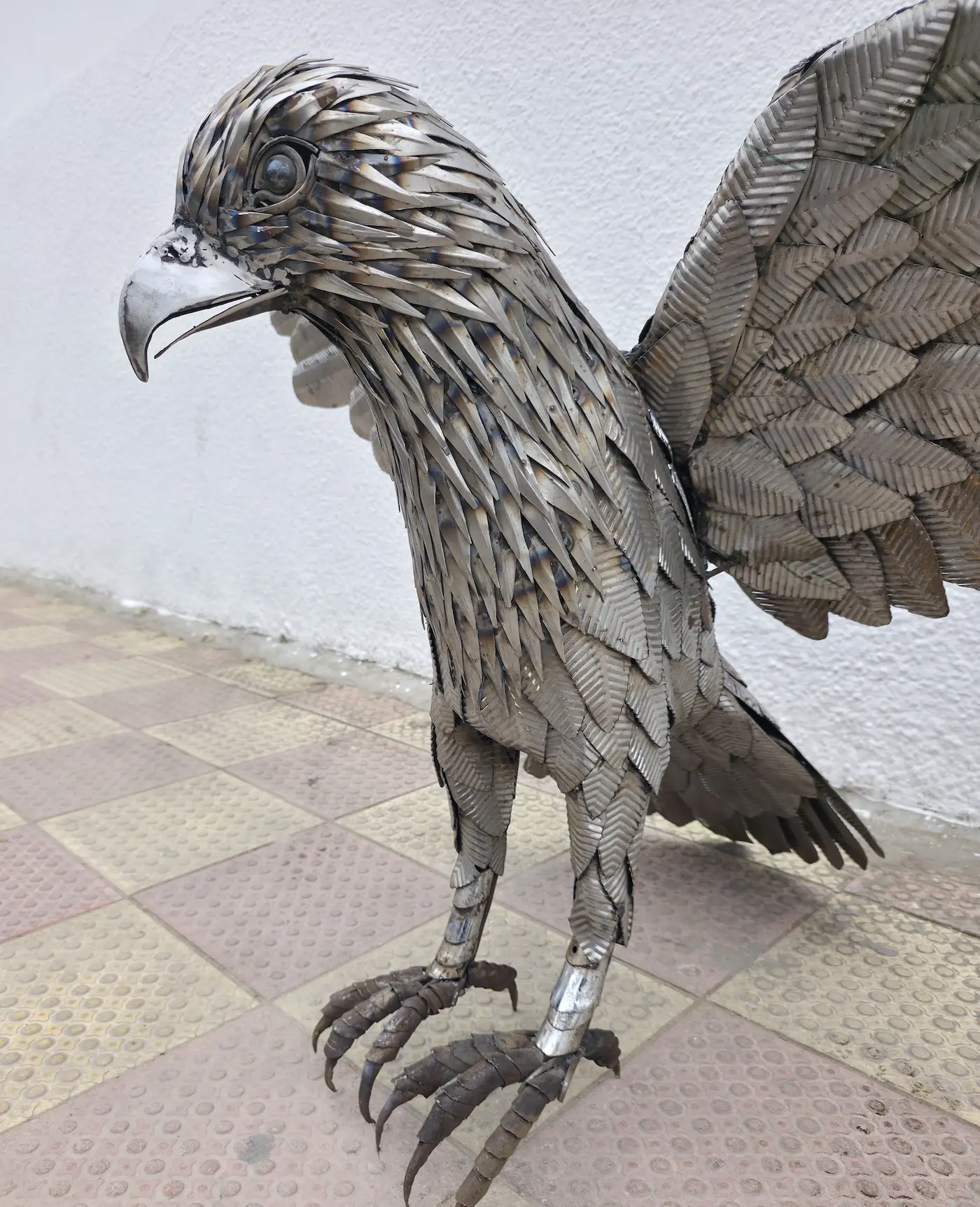 Aquila AKLAM — close-up testa, ogni piuma lavorata singolarmente